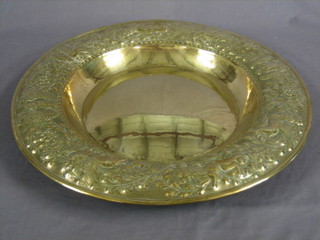 A circular embossed brass charger 22"