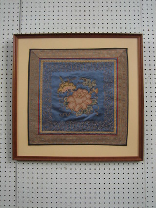 A Chinese square blue ground embroidered panel depicting flowers 15" x 15"