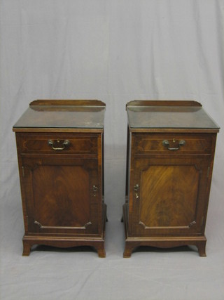 A pair of 1920's Georgian style inlaid mahogany bedside cabinets fitted a drawer above a cupboard, raised on bracket feet 61"