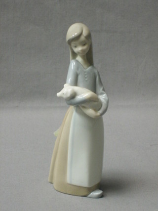 A Lladro figure of a standing girl holding a piglet, the base marked Lladro A-3E 7"