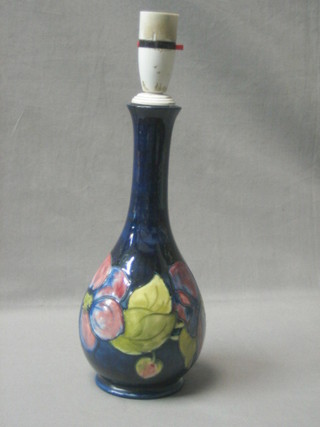 A Moorcroft blue glazed club shaped vase, the base with signature mark and impressed Moorcroft with paper label Potter to the Queen, 10" (drilled for a lamp base)