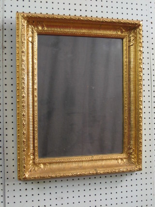 A rectangular plate mirror contained in a decorative gilt frame 20" x 15"
