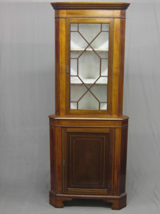 A  19th Century inlaid mahogany double corner cabinet, the upper section with moulded and dentil cornice, the base fitted a double cupboard enclosed by a panelled door, raised on bracket feet 30"