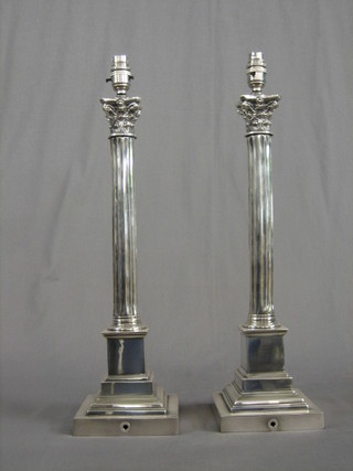 A pair of silver plated reeded column table lamps with Corinthian capitals