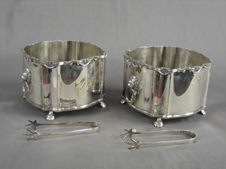 A pair of modern circular silver plated ice pails with wavy borders and lion ring mask drop handles, raised on paw feet 9" complete with tongs