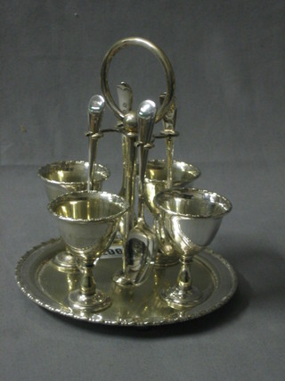 A circular silver plated 4 piece egg cruet complete with spoons