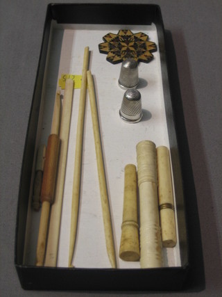 3 plain ivory cylindrical needle cases, a silver and 1 other thimble, 2 ivory crochet hooks, 2 ivory implements and a parquetry cotton winder