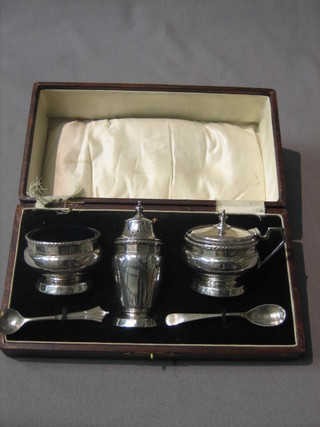 A 3 piece silver condiment set with mustard, salt and pepper pot Birmingham 1928, cased