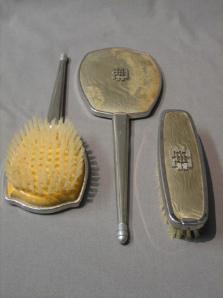 An Art Deco 3 piece simulated enamel and chromium plated dressing table set with hand mirror, hair brush and clothes brush