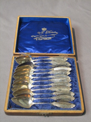 A set of 12 Continental silver spoons contained in a walnut box with hinged lid