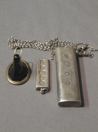 An intaglio cut seal, a 1977 Silver Jubilee ingot pendant, and a 1977 Silver jubilee cigarette lighter holder hung on a chain