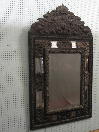 A 19th Century French bevelled plate mirror contained in an embossed metal frame 49"