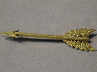 A gilt metal arrow brooch