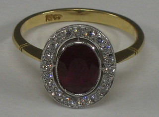 A lady's 18ct yellow gold dress ring set an oval cut ruby surrounded by numerous diamonds