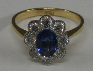 A lady's 18ct gold dress ring ring set an oval sapphire surrounded by 8 diamonds (approx 1ct/1.50ct)