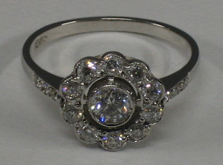 A lady's 18ct white gold cluster ring, set a central diamond surrounded by 10 diamonds and with 6 diamonds to the shoulders (approx 0.75ct)