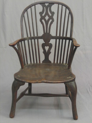 An 18th Century elm comb back carver chair with solid seat, raised on cabriole supports (old repair to arm)