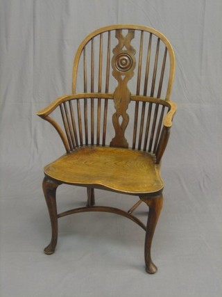 A 19th Century elm comb back carver chair with yew slat to the centre, raised on cabriole supports with cow horn stretcher
