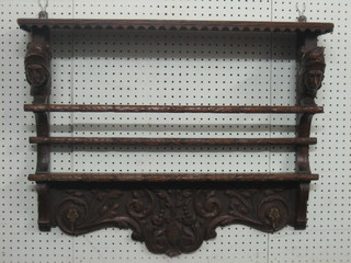 A Victorian Continental carved oak plate rack with mask decoration 30"