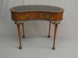 A figured walnut kidney writing table with black tooled leather writing surface, the base fitted 2 drawers, raised on cabriole supports with paw feet, 42"