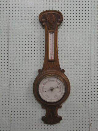 A Victorian wheel barometer and thermometer, contained in a carved oak case (glass f)