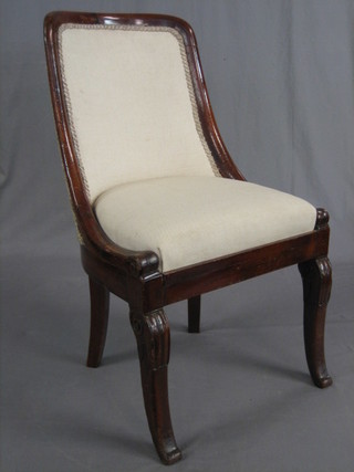 An Empire style mahogany tub back nursing chair raised on scrolled supports
