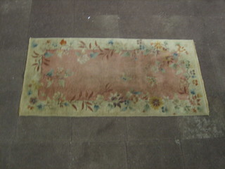 A 1930's peach and floral patterned rug 72" x 36"