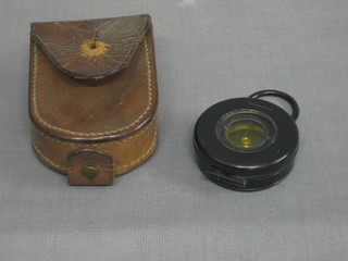 A prasmatic compass contained in a leather carrying case