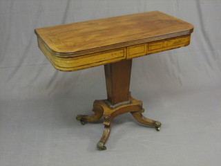 A William IV bleached mahogany and crossbanded tea table, raised on a chamfered column with triform base ending in splayed feet with brass paws, caps and castors 36" (1 foot with old repair)