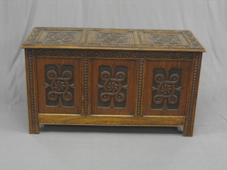 A 19th Century carved oak coffer of panelled construction with hinged lid, raised on square supports 49" 