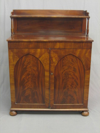 A handsome Victorian mahogany chiffonier with raised shelved back, the base fitted a cupboard enclosed by arch shaped panelled doors and raised on bun feet 36"