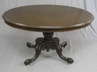 A Victorian oval oak snap top Loo table, raised on pillar and tripod supports 48"