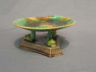 A 19th Century Majolica scallop shaped dish raised on 3 dolphin supports with triform base 9"