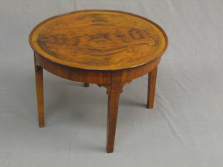 An Art Deco circular figured walnut coffee table, raised on square supports 23"