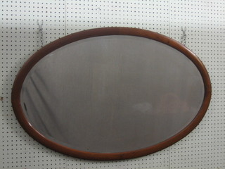 An Edwardian oval bevelled plate wall mirror contained in an inlaid mahogany frame 38"