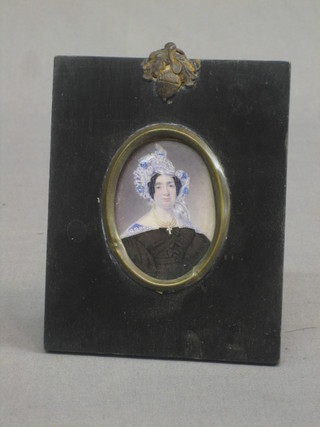 A 19th Century head and shoulders portrait miniature on ivory of a bonnetted lady, 2" oval, contained in an ebony frame