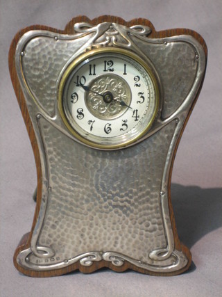 An Edwardian travelling clock with paper dial and Arabic numerals, contained in an oak and planished silver easel case, Birmingham 1906