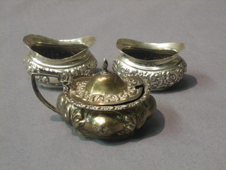 An Edwardian embossed silver 3 piece condiment set comprising oval mustard pot and 2 salts, Birmingham 1903