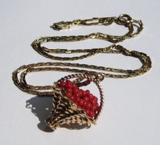 A lady's "gold" charm in the form of a basket of coral fruit, hung on a gold chain