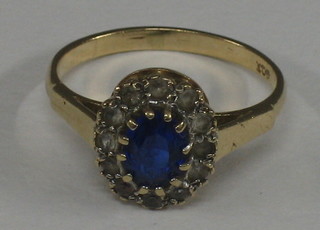 A lady's 9ct gold dress ring set an oval blue stone supported by white stones
