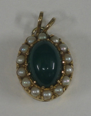 A modern 9ct gold pendant set a cabouchon cut green stone, supported by demi-pearls