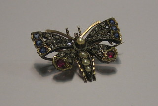 A lady's very attractive gold brooch in the form of an insect, the body set demi-pearls, the wings set diamonds, sapphires and rubies