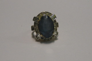 A lady's dress ring set a large blue stone surrounded by white stones (shank marked 15k)