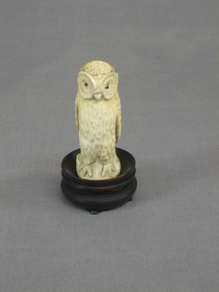 A carved ivory figure of an owl with hardstone eyes 3"