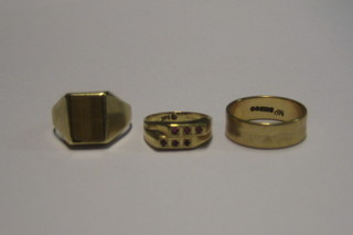 A 9ct gold dress ring set 6 red stones, a 9ct gold wedding band and a 9ct gold signet ring