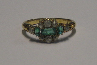 A lady's 18ct gold dress ring set a green stone supported by diamonds