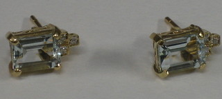 A pair of gold and aquamarine ear studs set 3 diamonds to the top