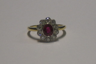 A lady's 18ct gold dress ring set an oval cut ruby surrounded by 10 diamonds (approx 0.45/0.75ct)