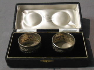 A pair of Eastern embossed silver napkin rings cased