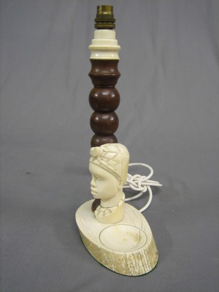 An African ivory and turned hardwood table lamp the base incorporating an ashtray supported by a native's head 15"
